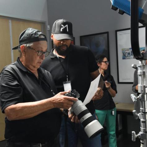 Two people looking at camera viewer. 
