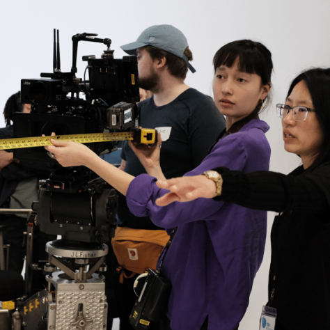 People working with cameras and measuring tape. 