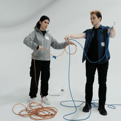Two people working with cables. 