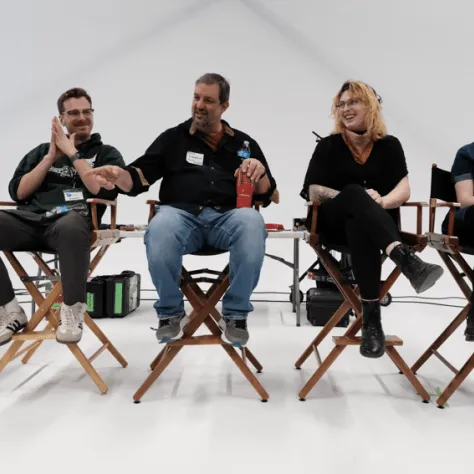 People sitting in chairs at the front of the room. 