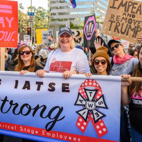 People standing with signs and a banner