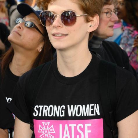 Person wearing sunglasses and a T-shirt that reads "STRONG WOMEN STRONG UNIONS IATSE"