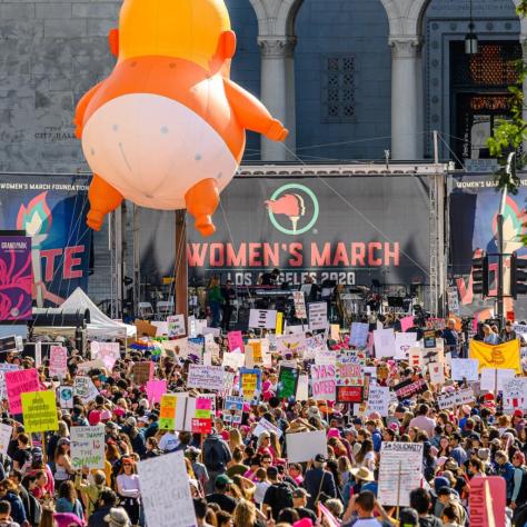 A balloon of baby Trump in a diaper floats above the crowd