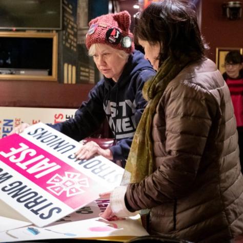 Women pulling out signs