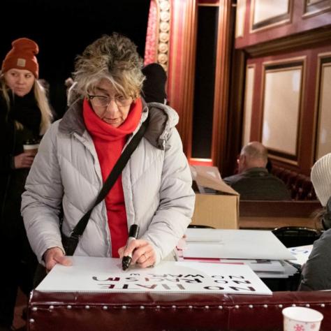 Woman writing words on a sign