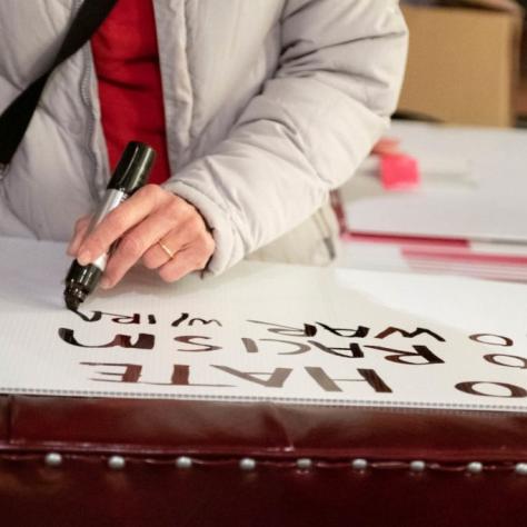 Woman writing words on a sign