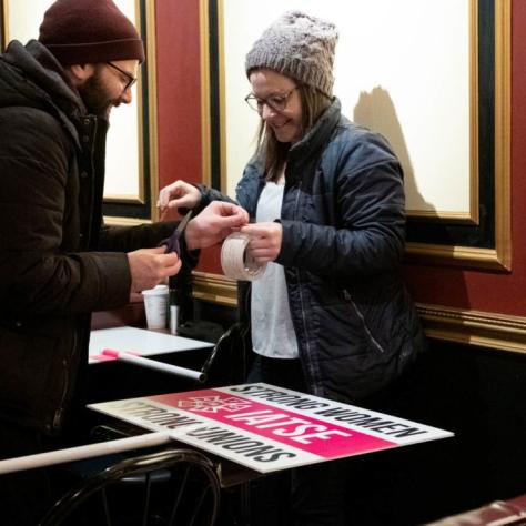 Man and woman cutting tape for a sign