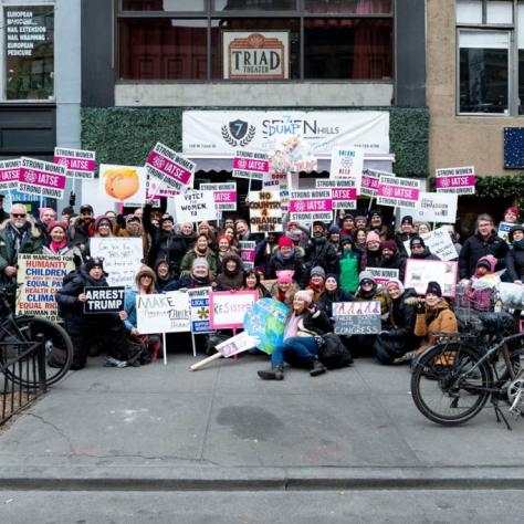 Group of people posing for a photo while holding their signs