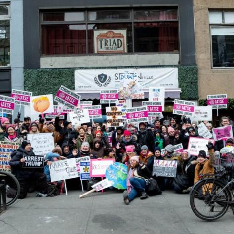 Group of people pose for a photo while holding their signs