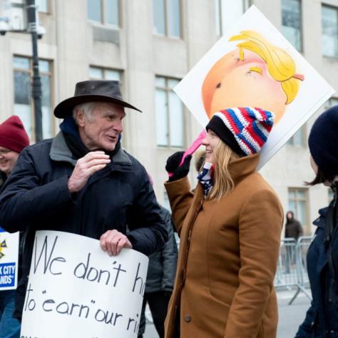 Man and woman talking while marching with signs