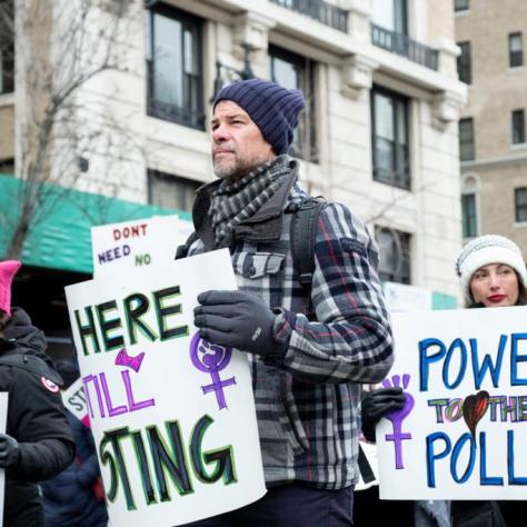 Man marching while holding sign