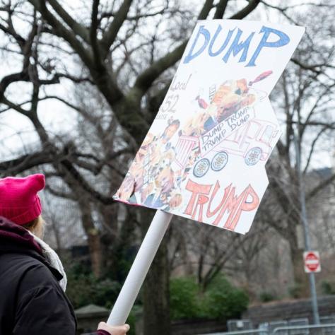 Woman holds sign that reads "DUMP TRUMP"