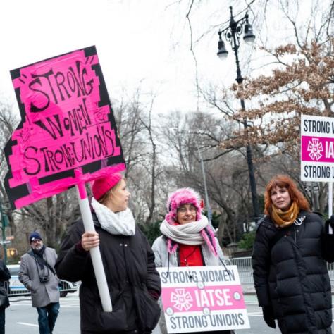 Women holding signs that read "STRONG WOMEN STRONG UNIONS"