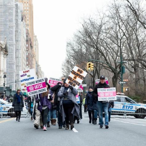 People holding signs march down the street