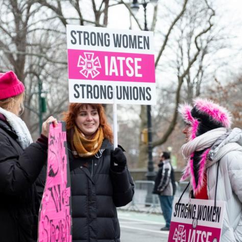 Women holding signs and chatting