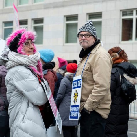 People with signs hanging from their necks