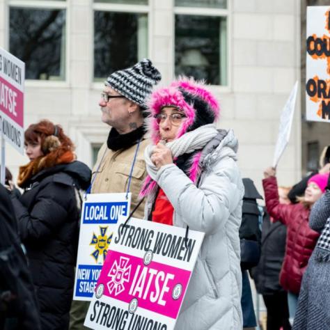 People marching while holding signs