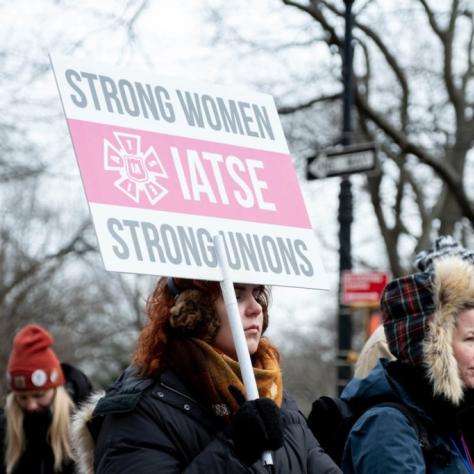 People marching while holding signs