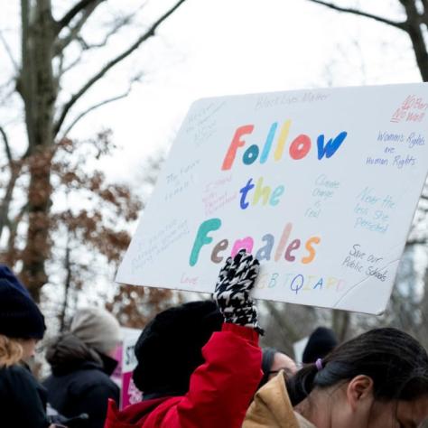 Woman holding sign that reads "Follow the Females"