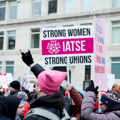 People marching while holding signs