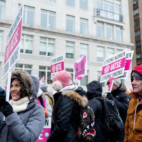 People marching while holding signs