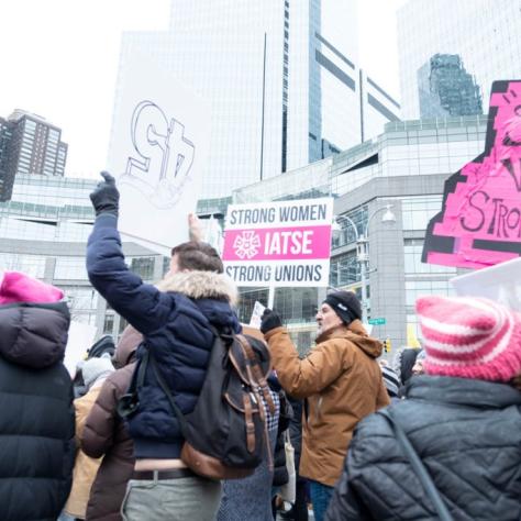 People marching while holding signs