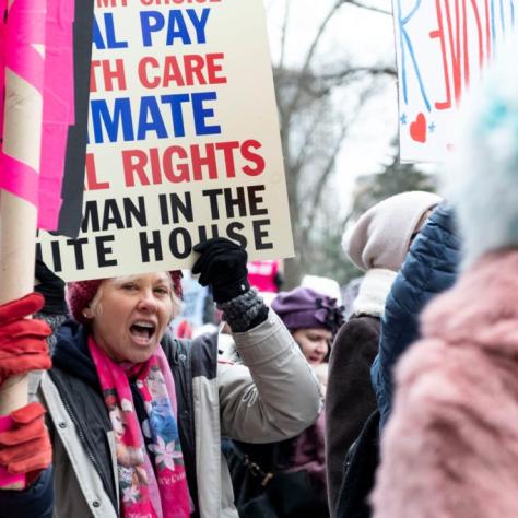 People marching while holding signs