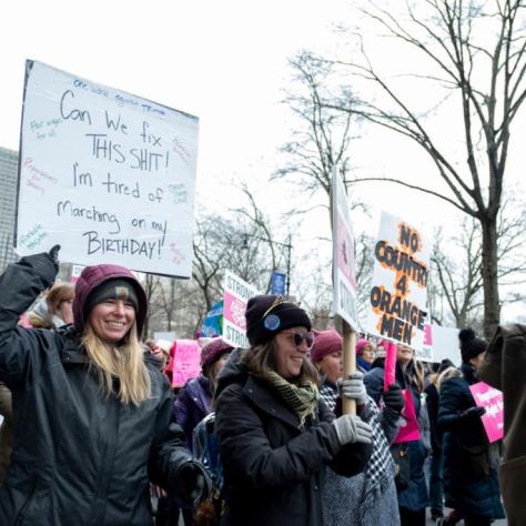 People marching while holding signs