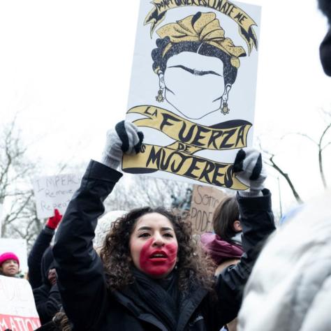 People marching while holding signs