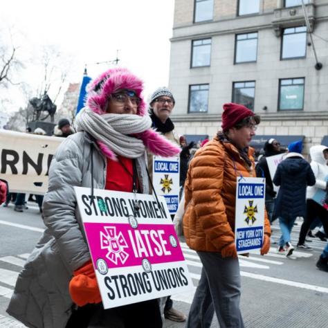 People marching while holding signs