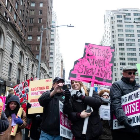 People marching while holding signs