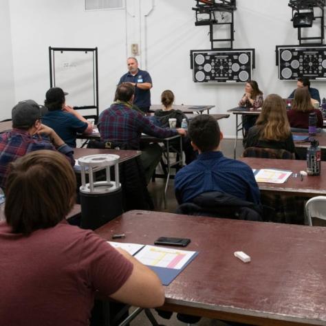 Man speaks in front of seated students