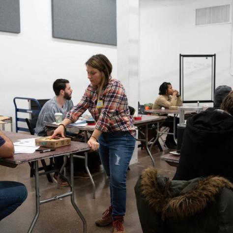 Woman explains something to a seated student