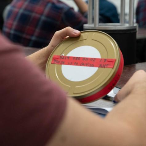 A man holding a film canister