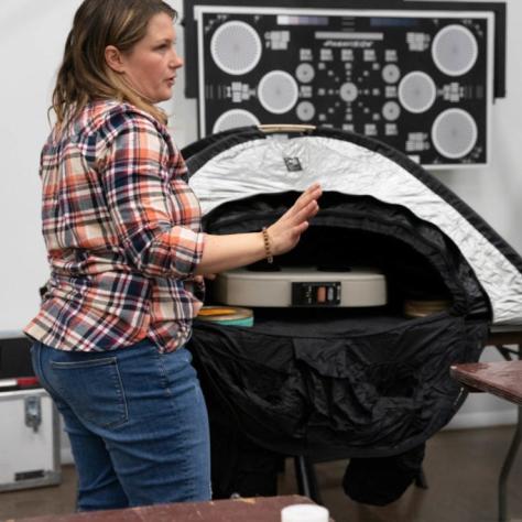 Woman shows the tent unzipped with the film loader inside