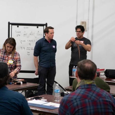A man holds film while students watch