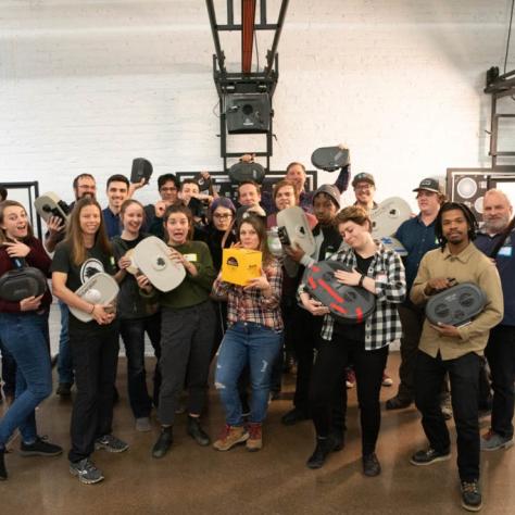 Group of people pose for a photo holding film loaders