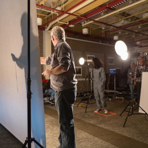 Man stands between a light source and a backdrop