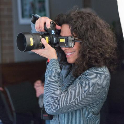 Woman looks through the viewfinder of a camera