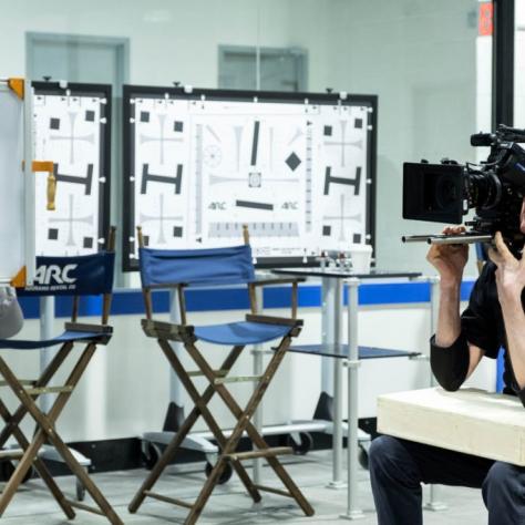 Man sits holding a camera
