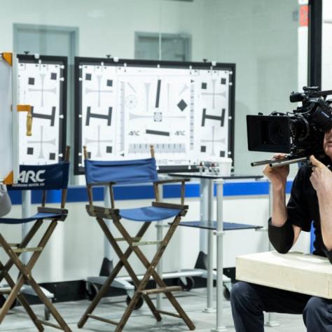 Man sits holding a camera
