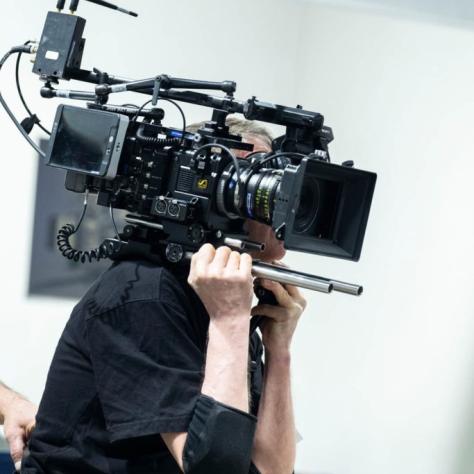Man with camera demonstrates to students
