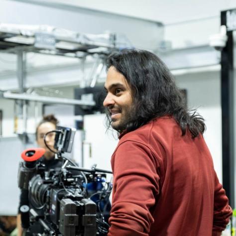 Man with camera demonstrates to students