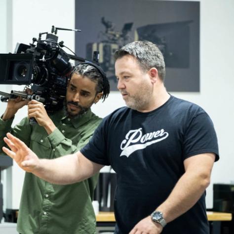 Man with camera demonstrates to students