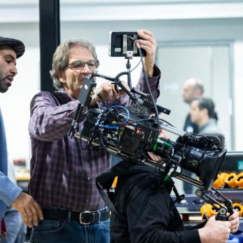 Man with camera demonstrates to students