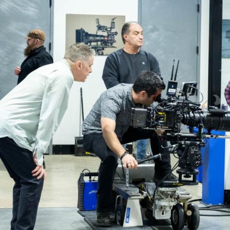 Man with camera demonstrates to students