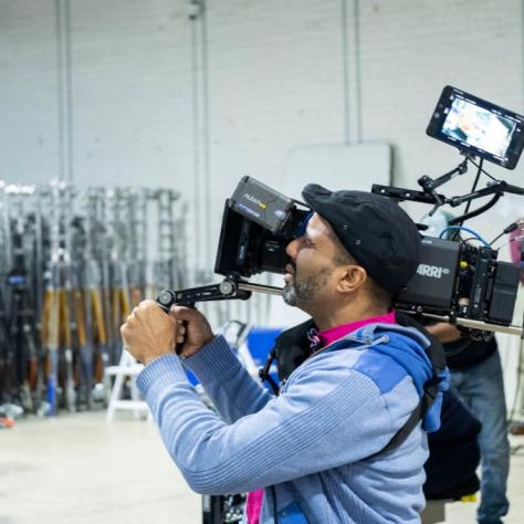 Man with camera demonstrates to students