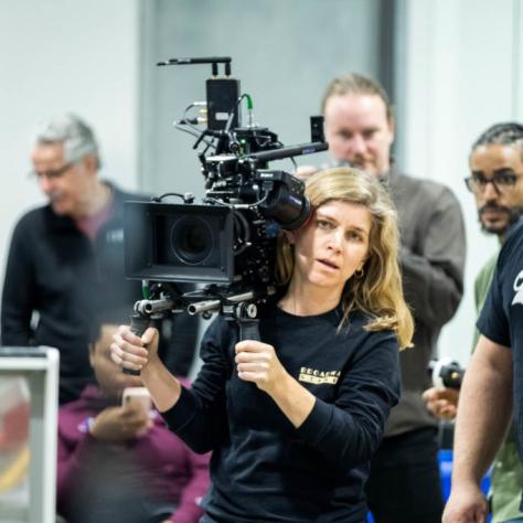 Woman with camera demonstrates to students