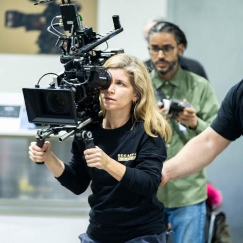 Woman with camera demonstrates to students