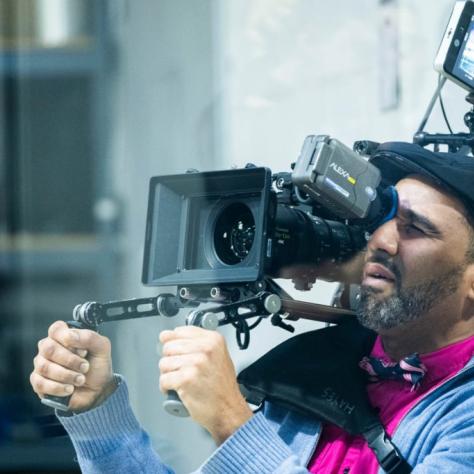 Man with camera demonstrates to students